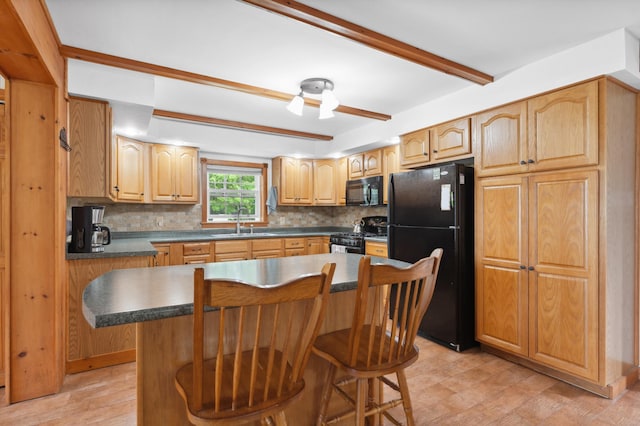 kitchen featuring a center island, sink, a kitchen breakfast bar, black appliances, and backsplash