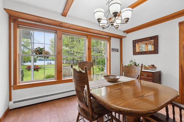 dining space with an inviting chandelier, a baseboard radiator, hardwood / wood-style floors, and a healthy amount of sunlight