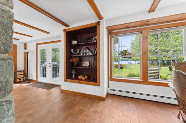 interior space with a baseboard radiator, plenty of natural light, and hardwood / wood-style flooring