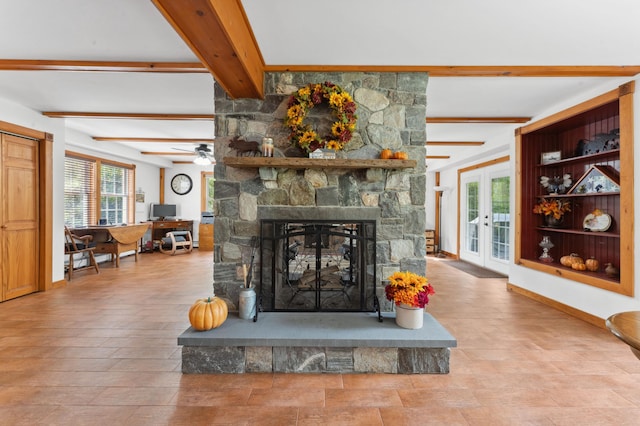 living room featuring a stone fireplace, beamed ceiling, wood-type flooring, ceiling fan, and french doors