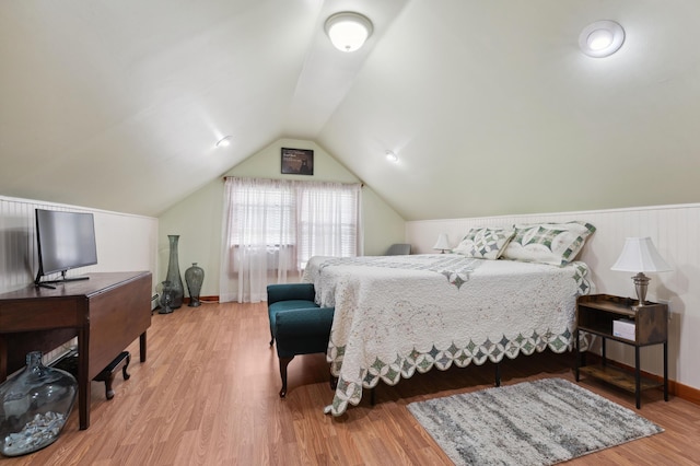 bedroom with vaulted ceiling and hardwood / wood-style floors