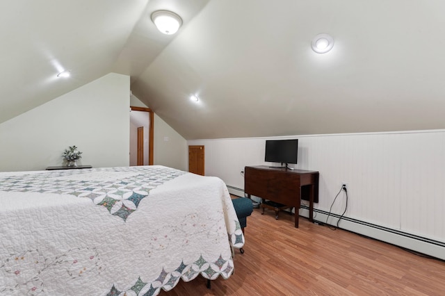 bedroom with a baseboard radiator, lofted ceiling, and hardwood / wood-style floors