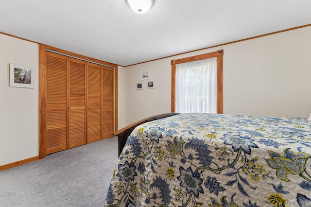 bedroom featuring a textured ceiling, a closet, crown molding, and carpet flooring