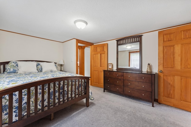 bedroom with a textured ceiling, ornamental molding, and light colored carpet