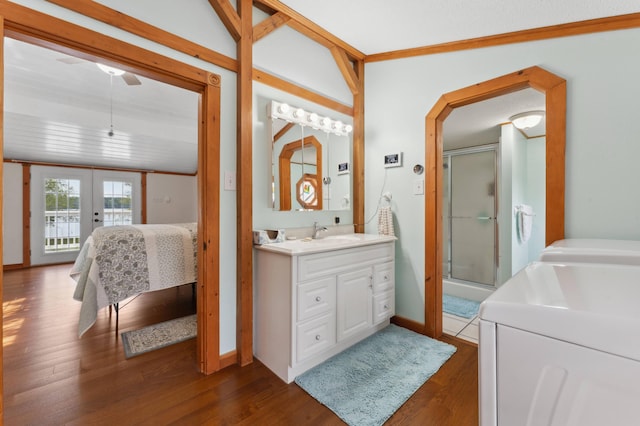 bathroom featuring vanity, french doors, washer and clothes dryer, hardwood / wood-style flooring, and walk in shower