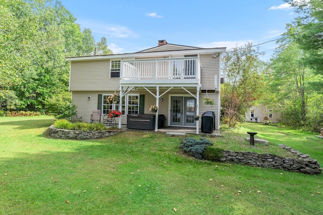 back of property with french doors and a yard