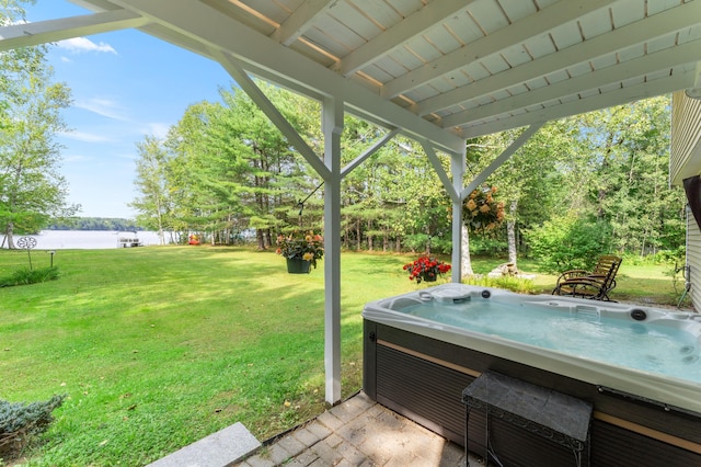 view of yard with a hot tub and a water view