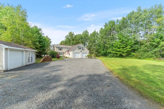 view of front of property with a front yard, an outdoor structure, and a garage