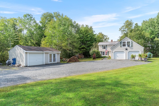 view of front of house with an outdoor structure, a garage, and a front lawn