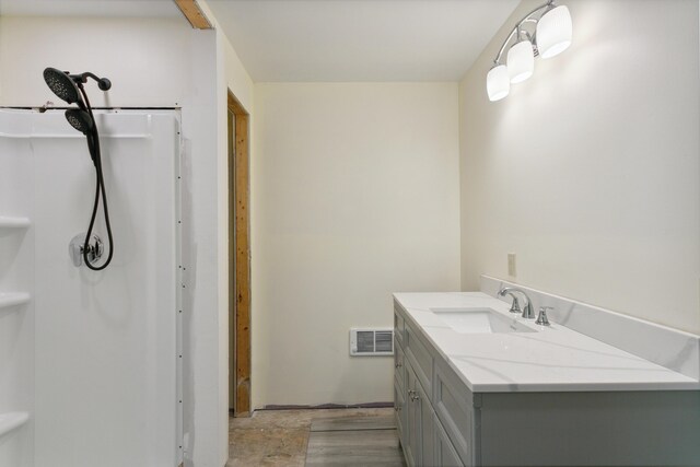 bathroom featuring walk in shower and vanity