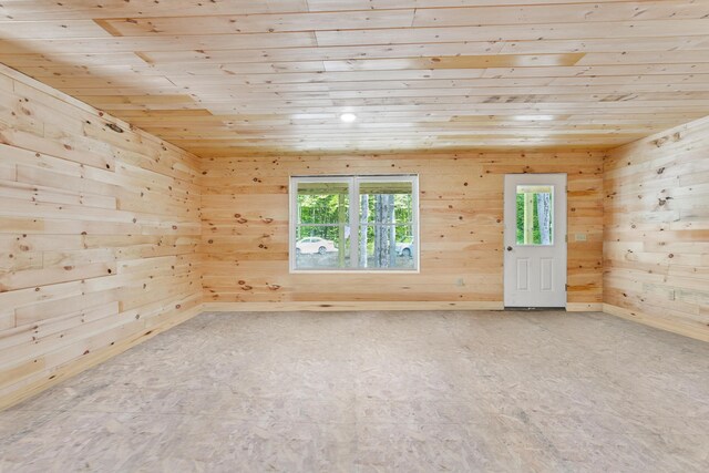 spare room featuring wooden ceiling, wood walls, and plenty of natural light