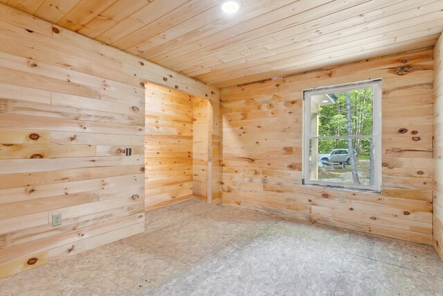 spare room with wood ceiling and wooden walls