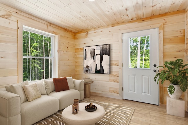 living room with wood walls, light hardwood / wood-style floors, and wooden ceiling