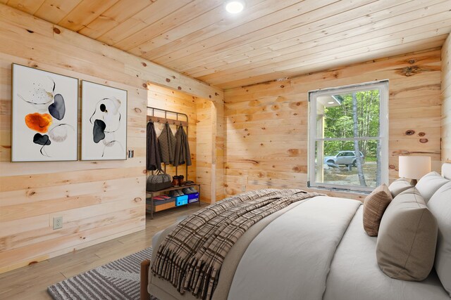 bedroom with wood-type flooring, wood ceiling, and wooden walls