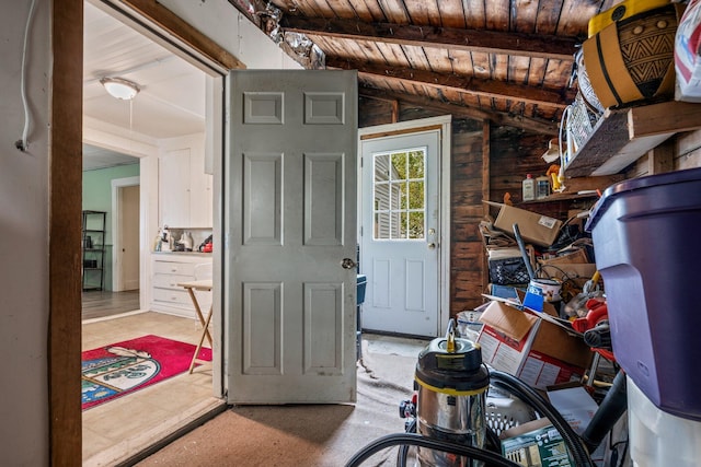 foyer entrance with vaulted ceiling with beams, wood ceiling, and wood walls