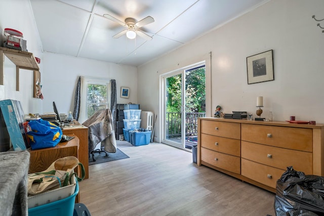 office space featuring ceiling fan, ornamental molding, and light hardwood / wood-style floors