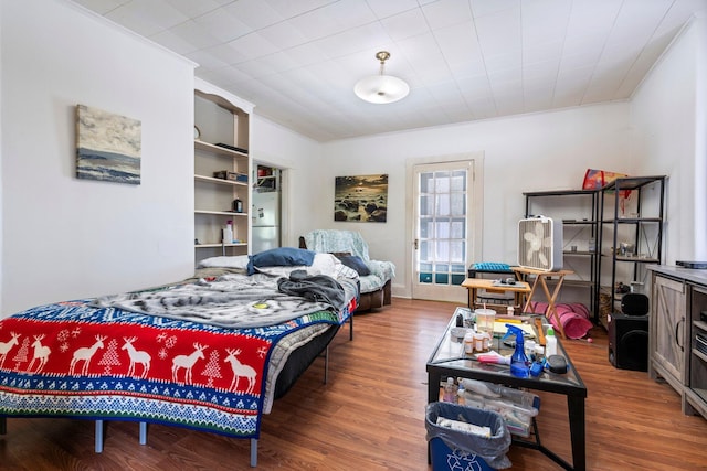 bedroom with wood finished floors and ornamental molding