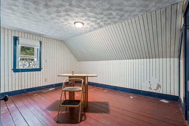 additional living space featuring wood-type flooring, baseboards, and lofted ceiling