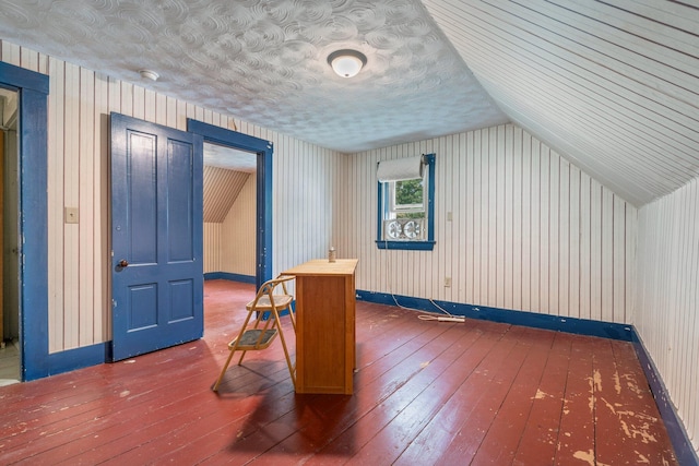 additional living space with baseboards, lofted ceiling, and hardwood / wood-style flooring