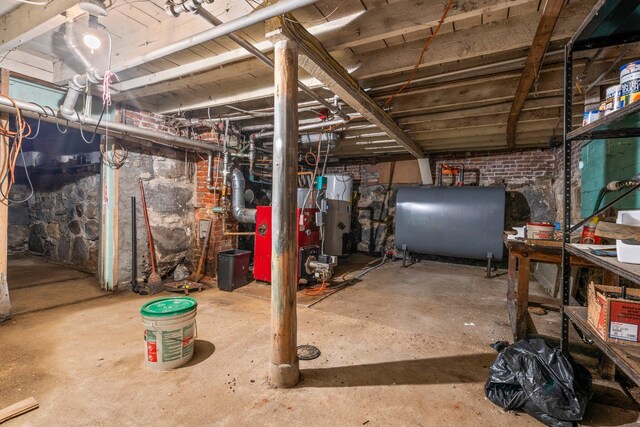 unfinished basement featuring electric water heater and heating fuel