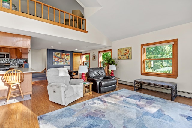 living room featuring light wood-type flooring, high vaulted ceiling, and baseboard heating