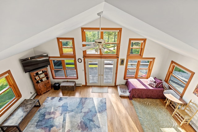 bedroom with french doors, light wood-type flooring, baseboard heating, ceiling fan, and lofted ceiling