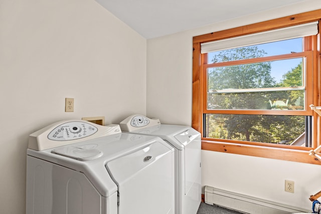 washroom with washing machine and dryer, a baseboard radiator, and plenty of natural light