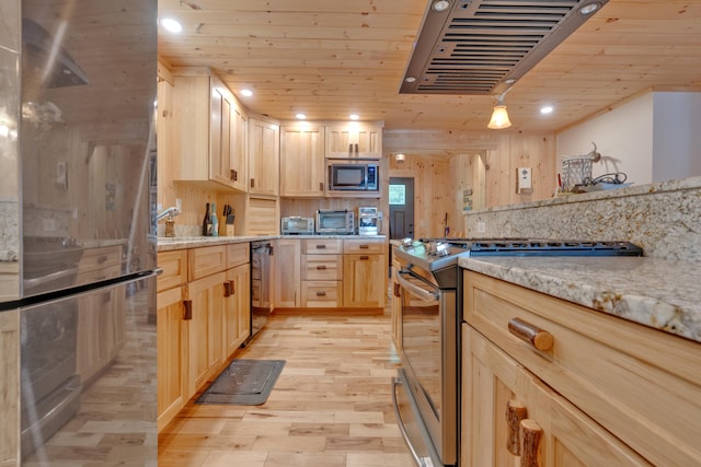 kitchen with appliances with stainless steel finishes, light stone countertops, exhaust hood, light wood-type flooring, and light brown cabinetry