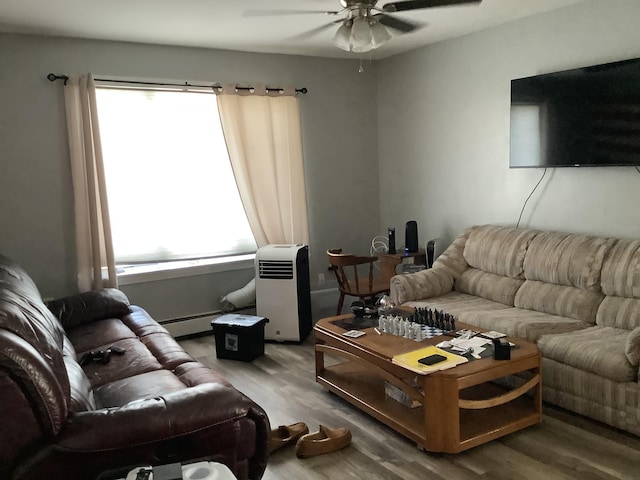 living room featuring ceiling fan, a baseboard heating unit, and hardwood / wood-style flooring