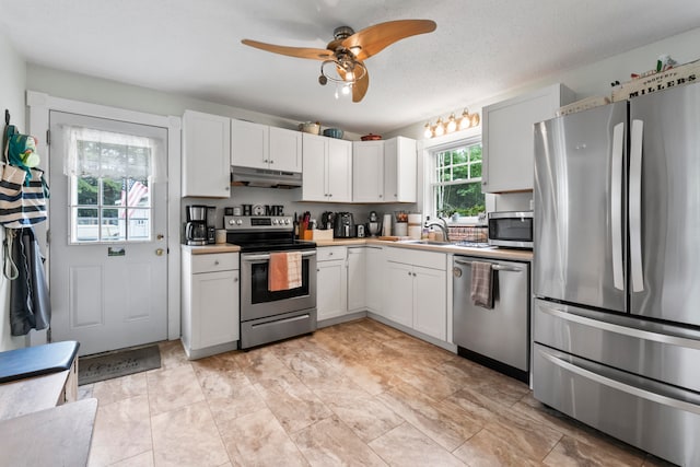 kitchen featuring stainless steel appliances, white cabinetry, ceiling fan, and a textured ceiling