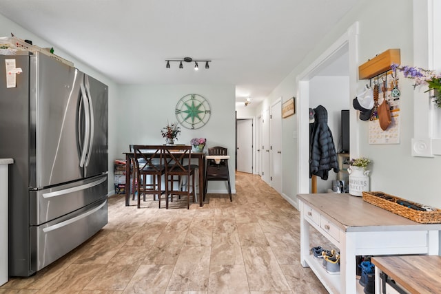 kitchen with stainless steel fridge and rail lighting