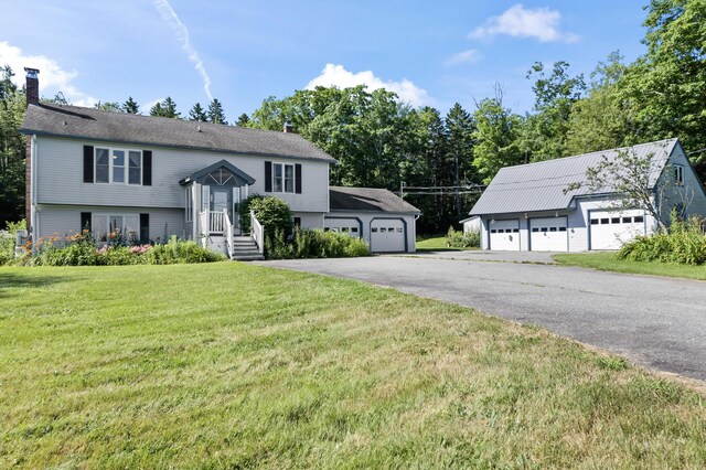 raised ranch with a front lawn and a garage