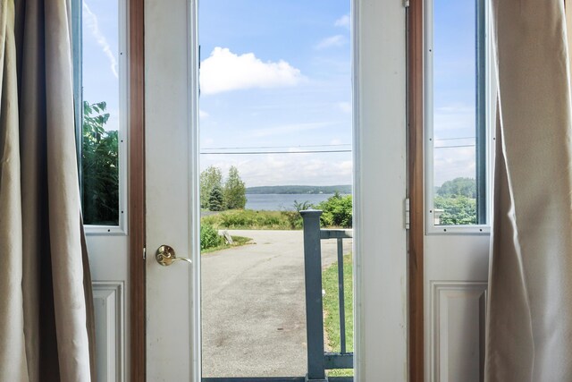 doorway featuring carpet floors and a water view