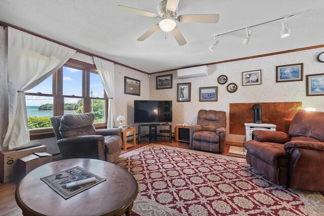 living room featuring ceiling fan, a textured ceiling, light hardwood / wood-style flooring, track lighting, and an AC wall unit