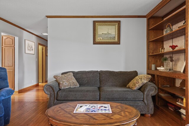 living room with light wood-type flooring and ornamental molding