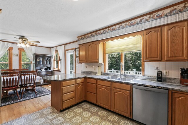 kitchen featuring kitchen peninsula, wood-type flooring, ceiling fan, stainless steel dishwasher, and sink