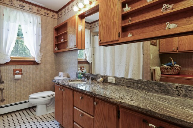 bathroom featuring vanity, toilet, ornamental molding, baseboard heating, and tile patterned flooring