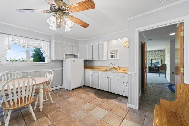 kitchen featuring white cabinetry, white fridge, crown molding, ceiling fan, and sink