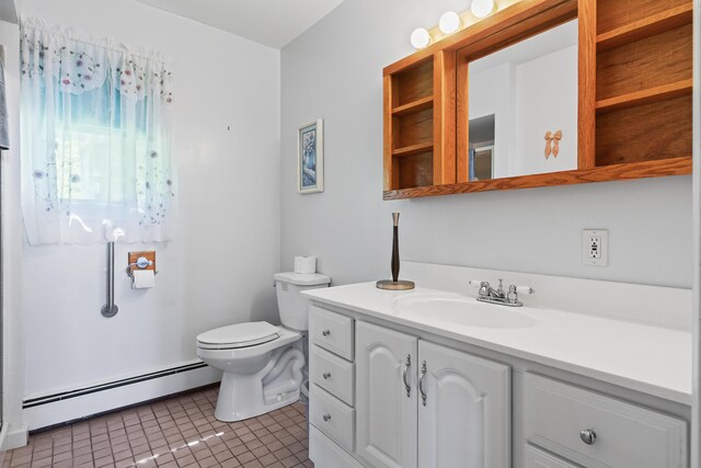 bathroom featuring toilet, vanity, baseboard heating, and tile patterned flooring