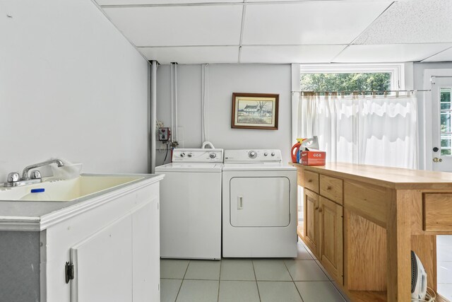 laundry area featuring light tile patterned floors, sink, and independent washer and dryer