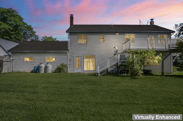 back house at dusk with a deck and a yard