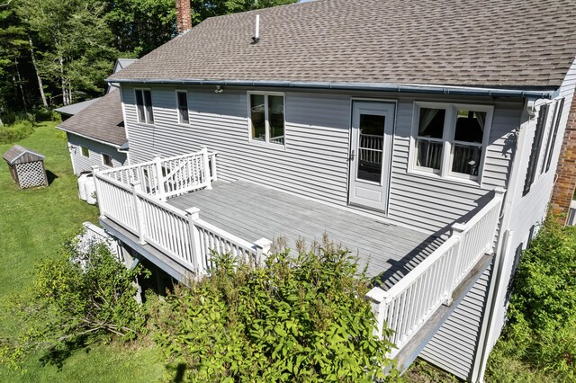 back of property featuring a deck and a yard