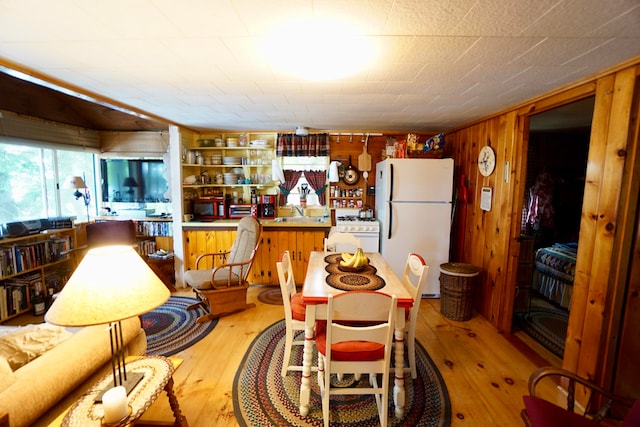 interior space featuring light wood-type flooring, wooden walls, and sink