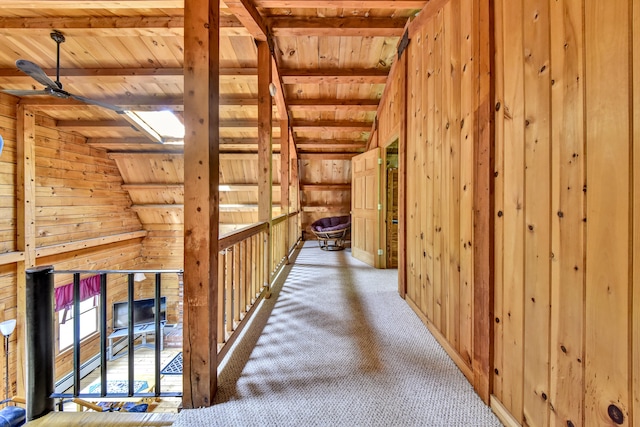 corridor featuring wooden walls, carpet, vaulted ceiling with beams, and wood ceiling