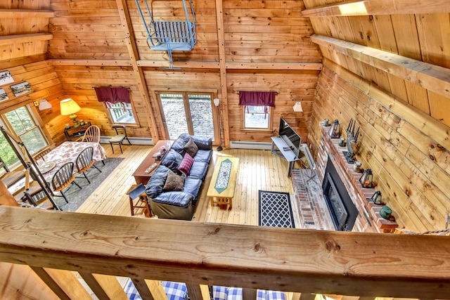 unfurnished living room with a brick fireplace, baseboard heating, and hardwood / wood-style floors