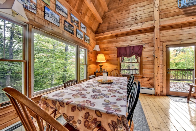 dining space with wood ceiling, wooden walls, high vaulted ceiling, a baseboard heating unit, and light hardwood / wood-style flooring