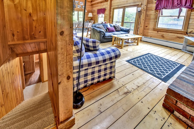 sitting room featuring a baseboard heating unit, wooden walls, and wood-type flooring