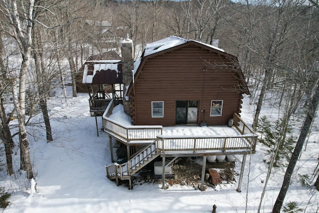 snow covered house featuring a wooden deck