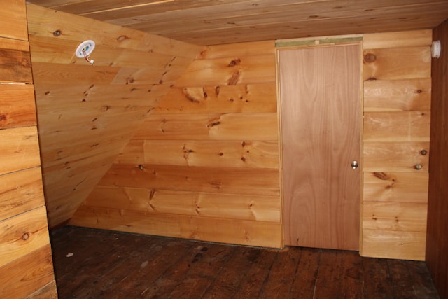 interior space with wood walls, wooden ceiling, and hardwood / wood-style floors