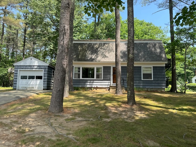 view of front of house featuring a garage, an outdoor structure, and a front lawn